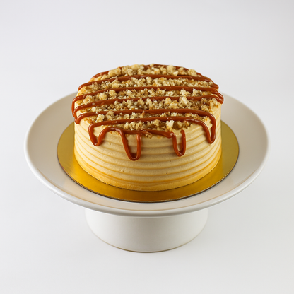 Dulce de leche cake with sableé crumble, caramel custard, and frosting — ready for pickup at Shelíss Bakeshop
